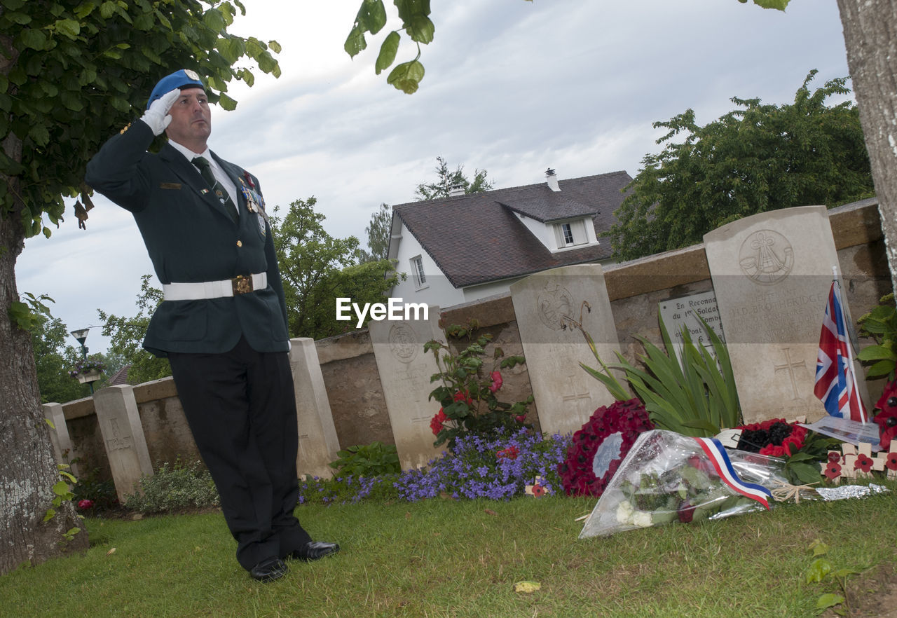 MAN STANDING IN FRONT OF LAWN