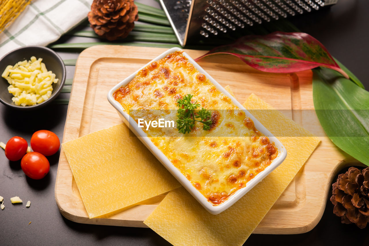High angle view of lasagne in container on cutting board