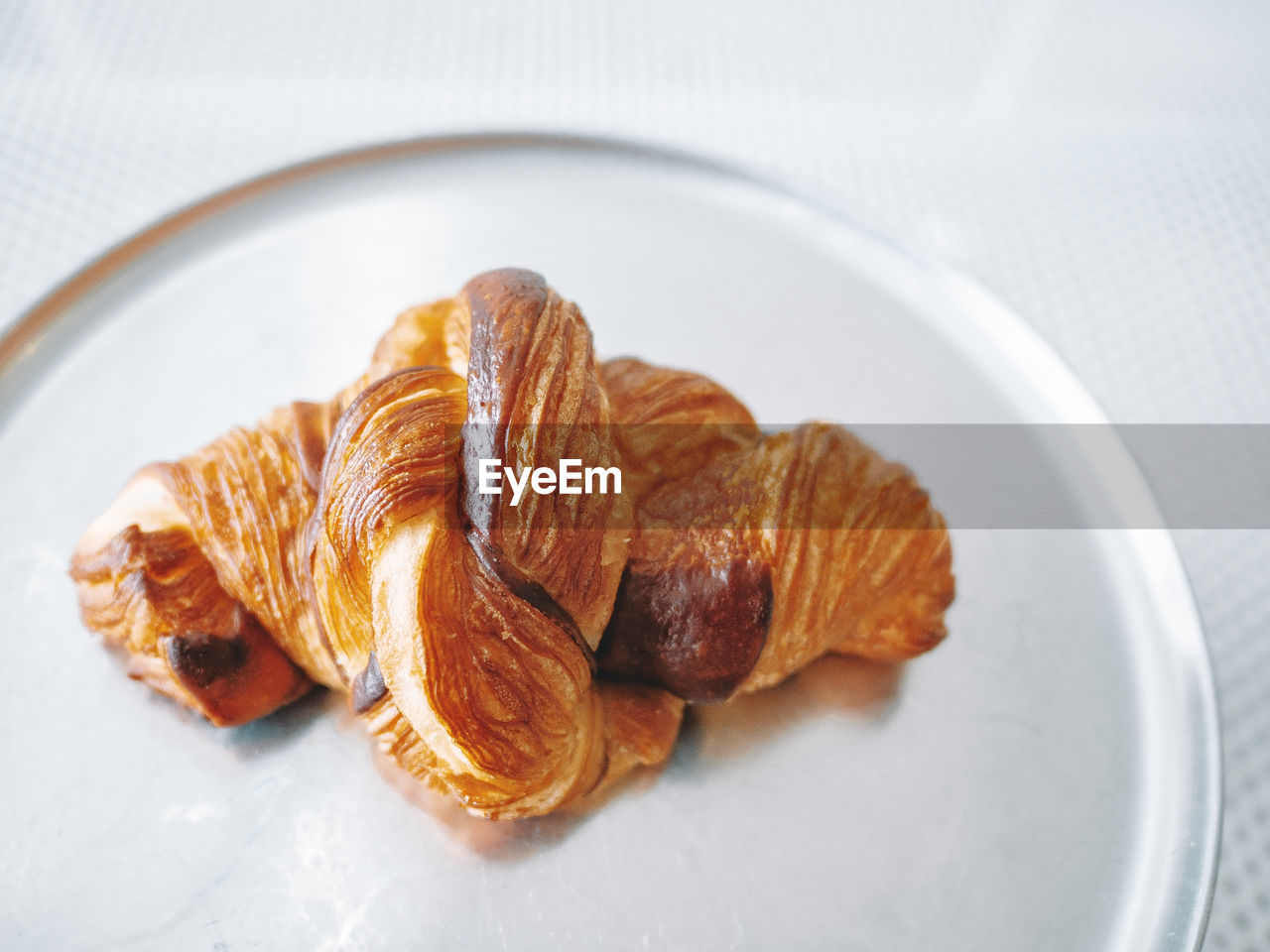 Croissants in a white plate on white table background