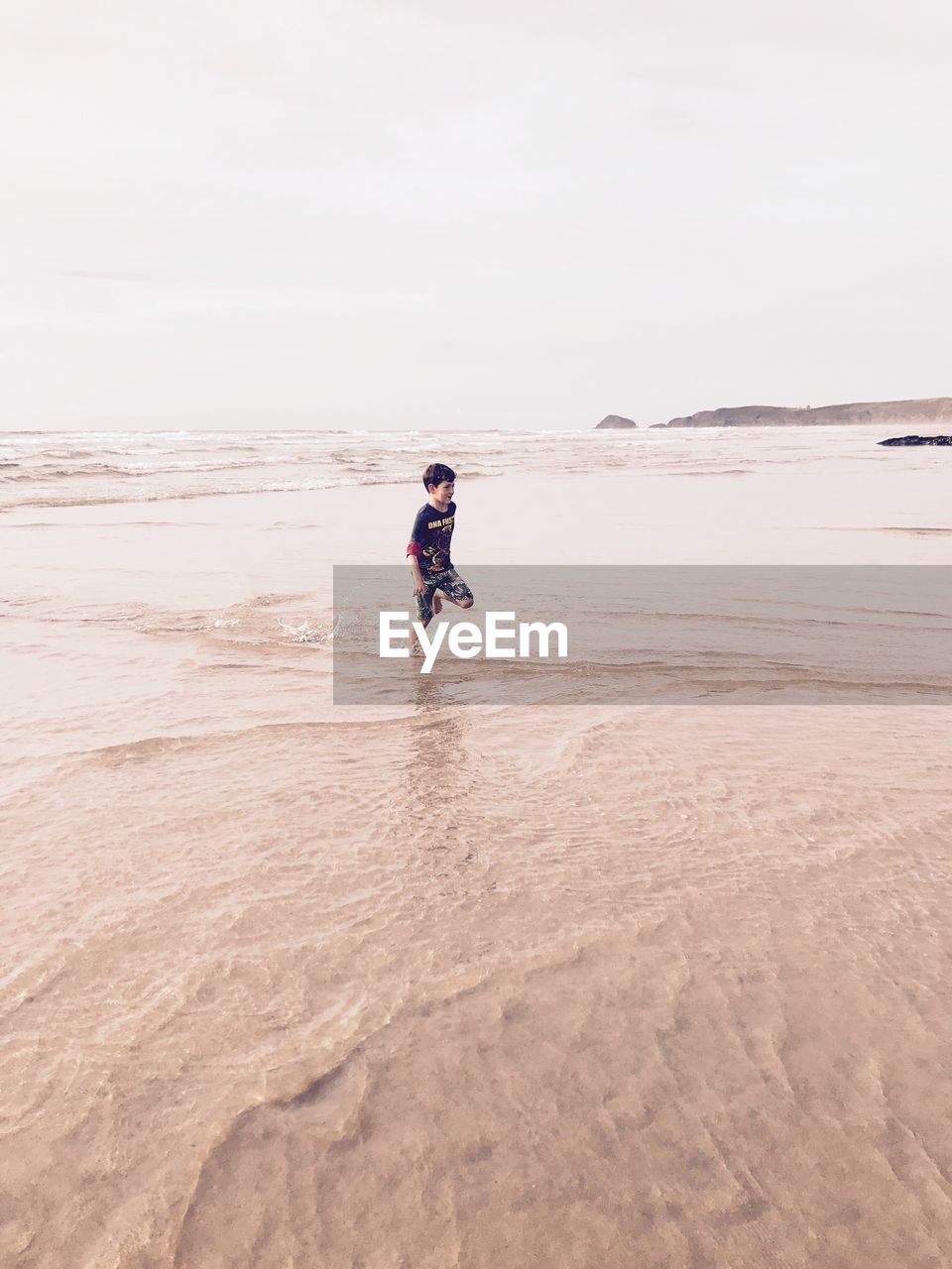 Full length of boy running on beach