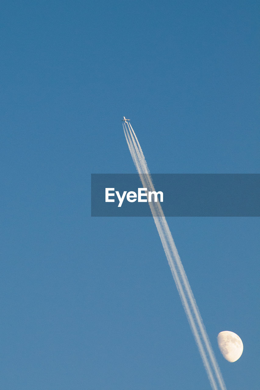 Low angle view of airplane flying against blue sky