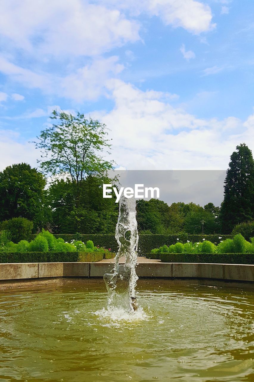 FOUNTAIN AGAINST TREES AND SKY