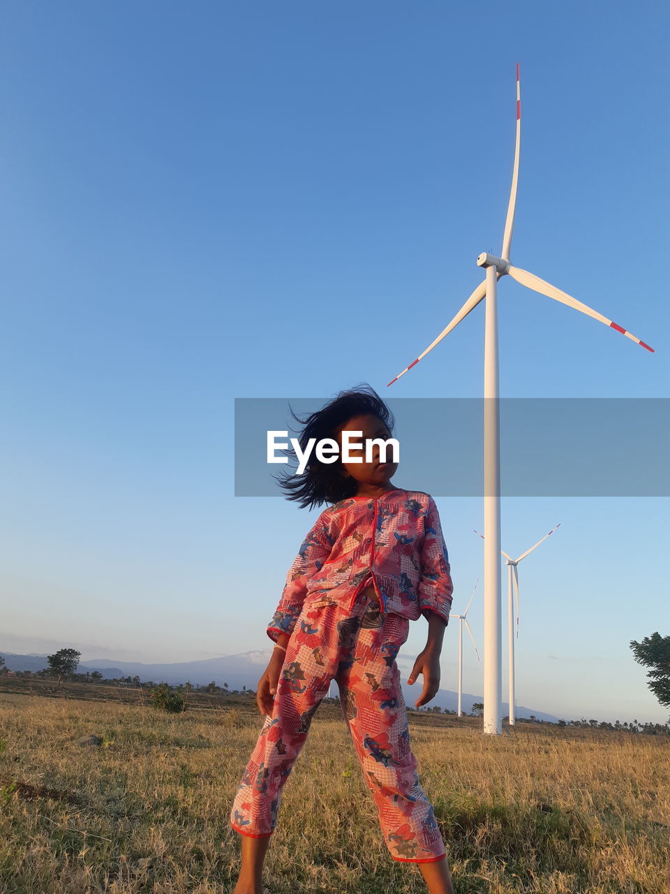 Woman standing on field against clear sky