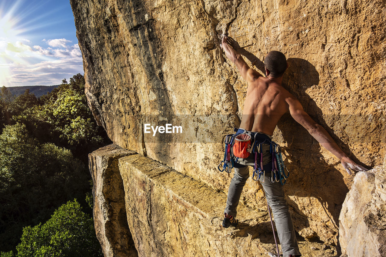 Full length of shirtless man standing on rock