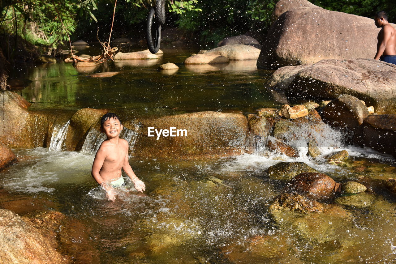 PORTRAIT OF SHIRTLESS BOY IN WATER