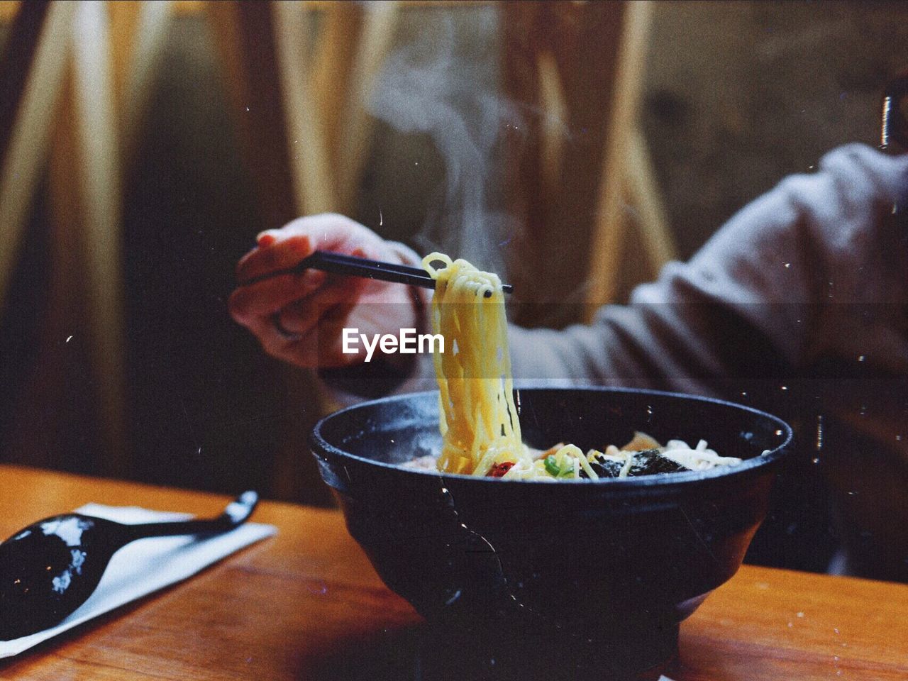 Cropped hand of person having noodles at home