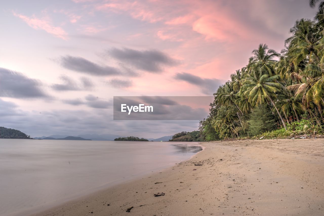 Scenic view of beach against pink sky