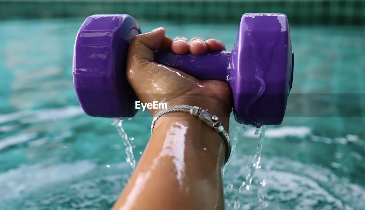 Low section of woman on wet swimming pool