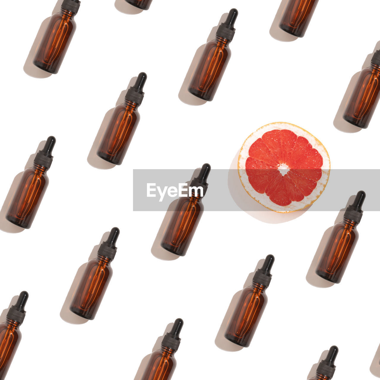 Seamless pattern of anti aging serum in glass bottle with dropper on white background.