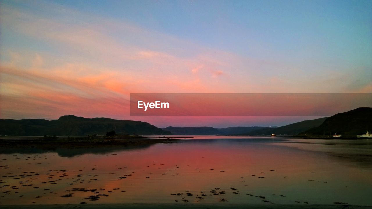 Scenic view of lake against romantic sky at sunset