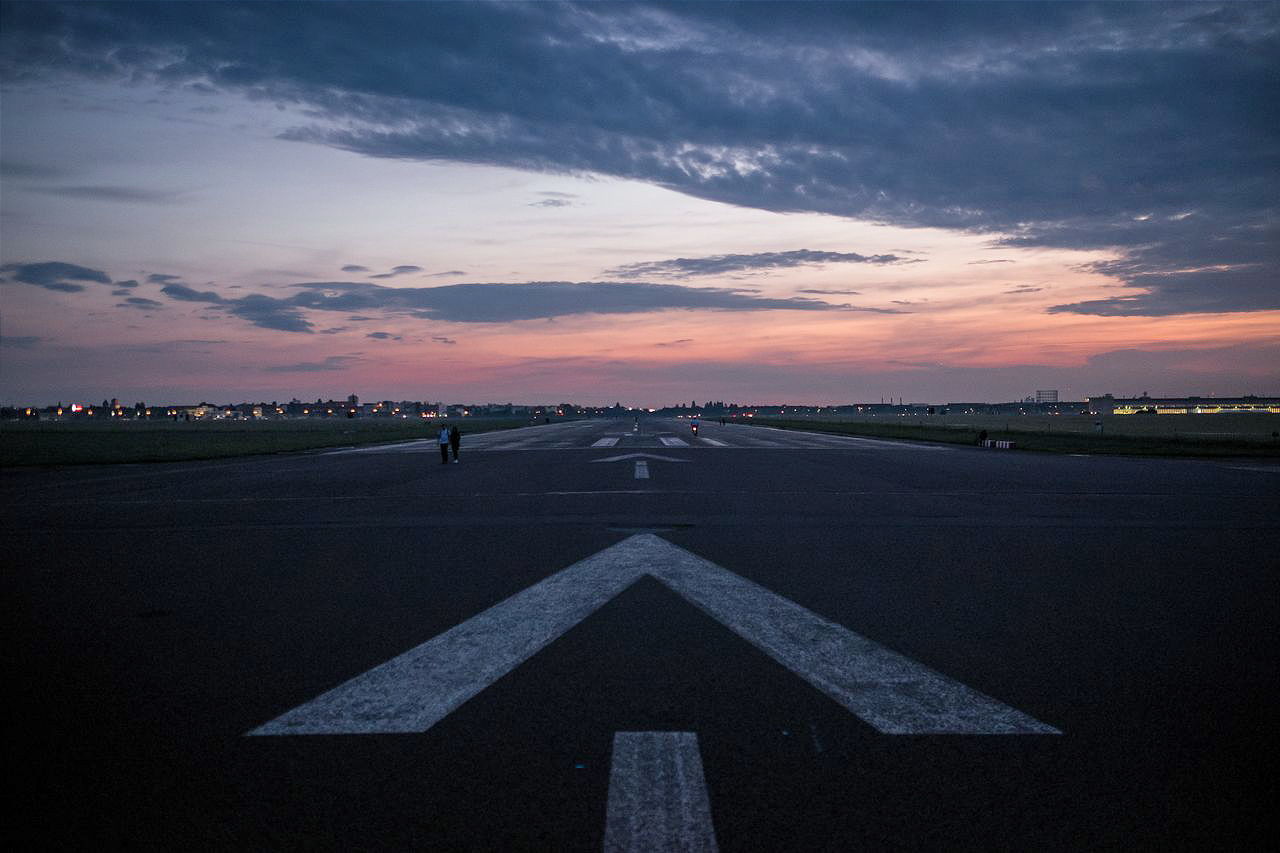 Runway against cloudy sky during sunset