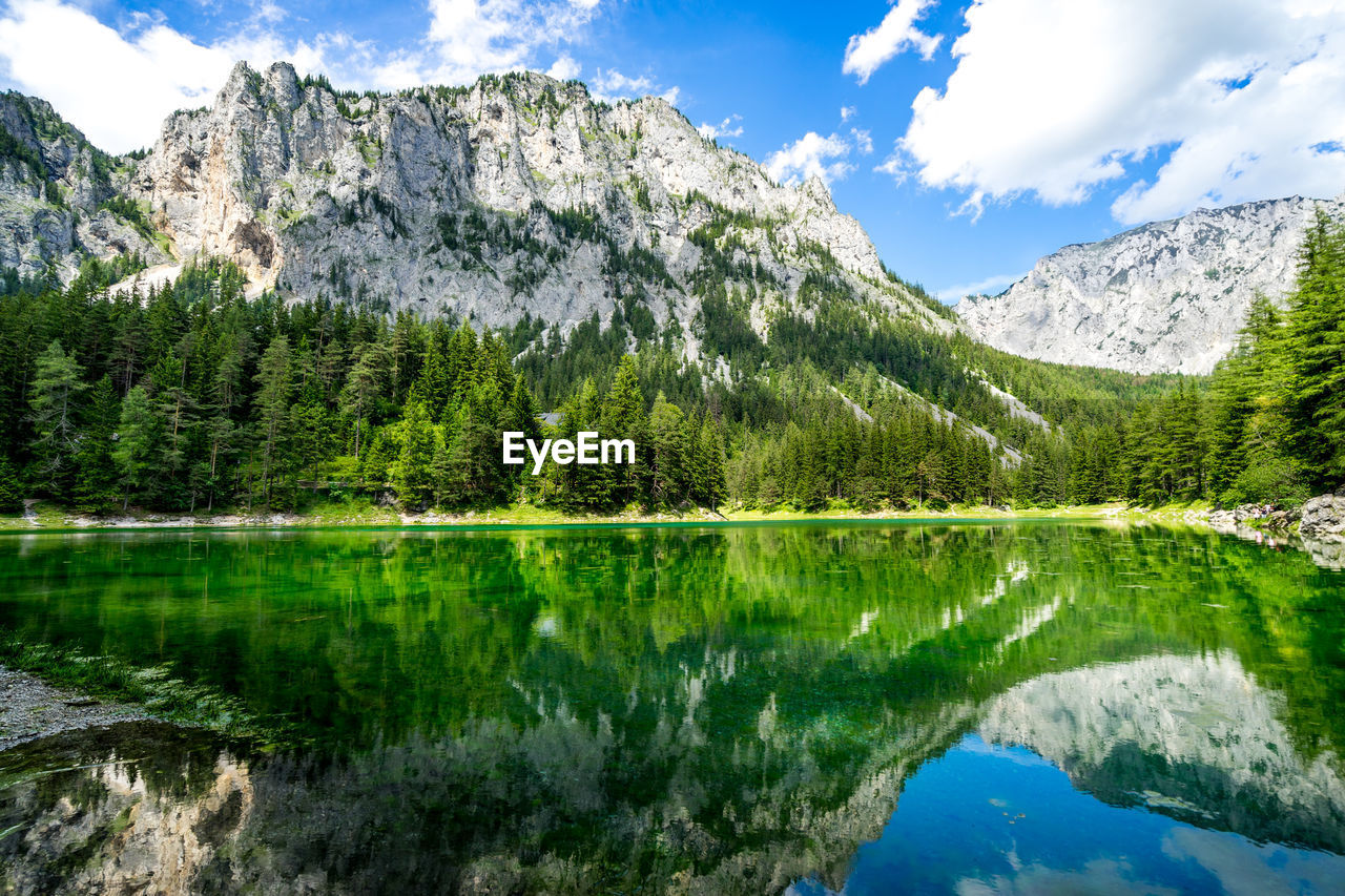 Scenic view of lake by mountains against sky