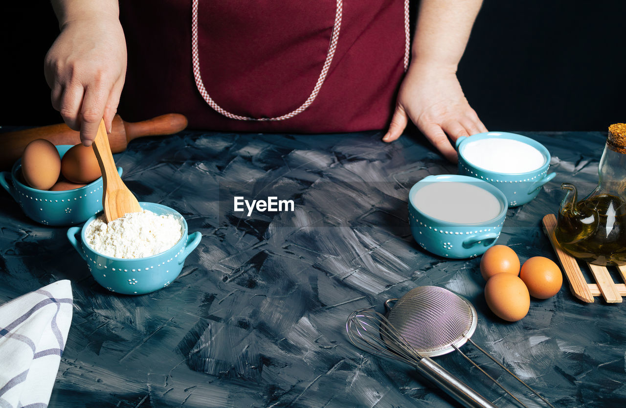 HIGH ANGLE VIEW OF MAN PREPARING FOOD ON CUTTING BOARD