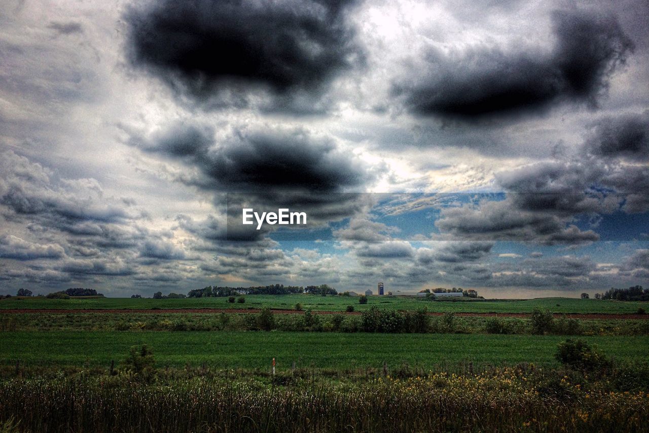 SCENIC VIEW OF STORM CLOUDS OVER FIELD