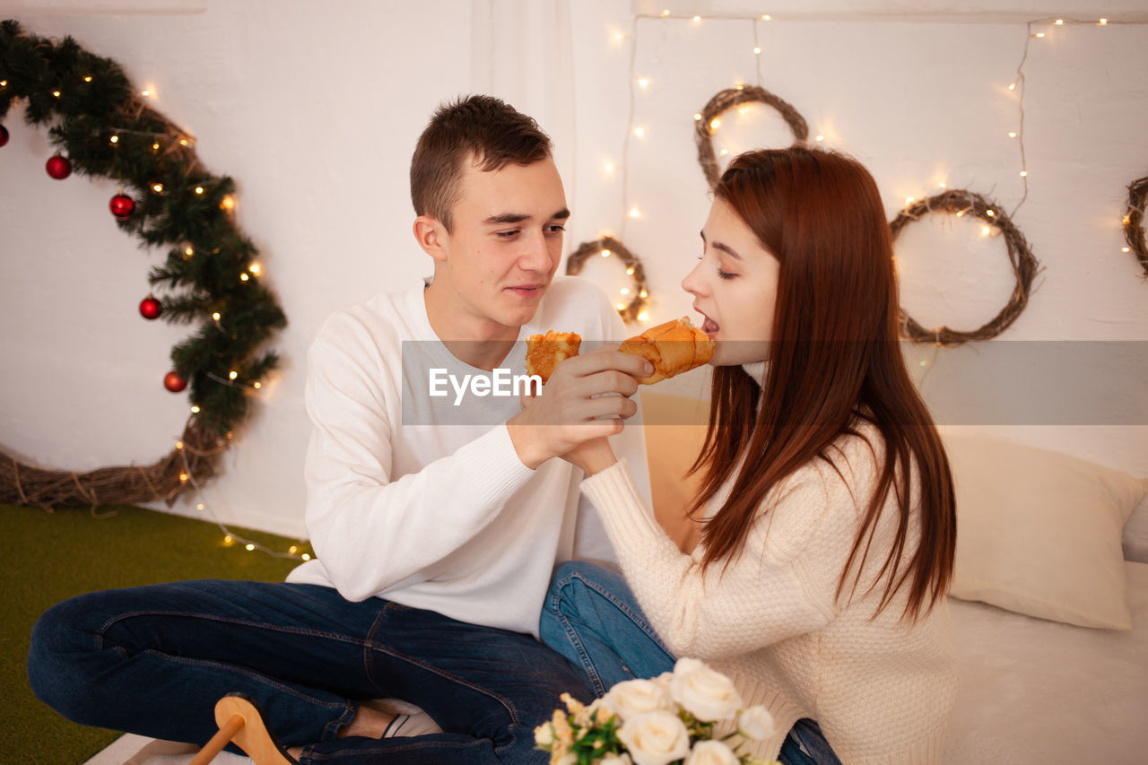 A young happy couple in love eats in a photo studio. the guy and the girl 
