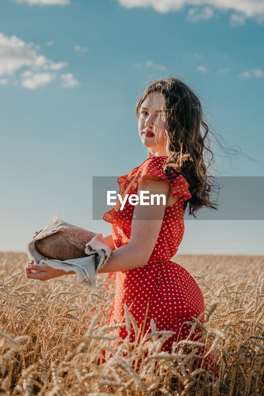 Midsection of woman on land against sky