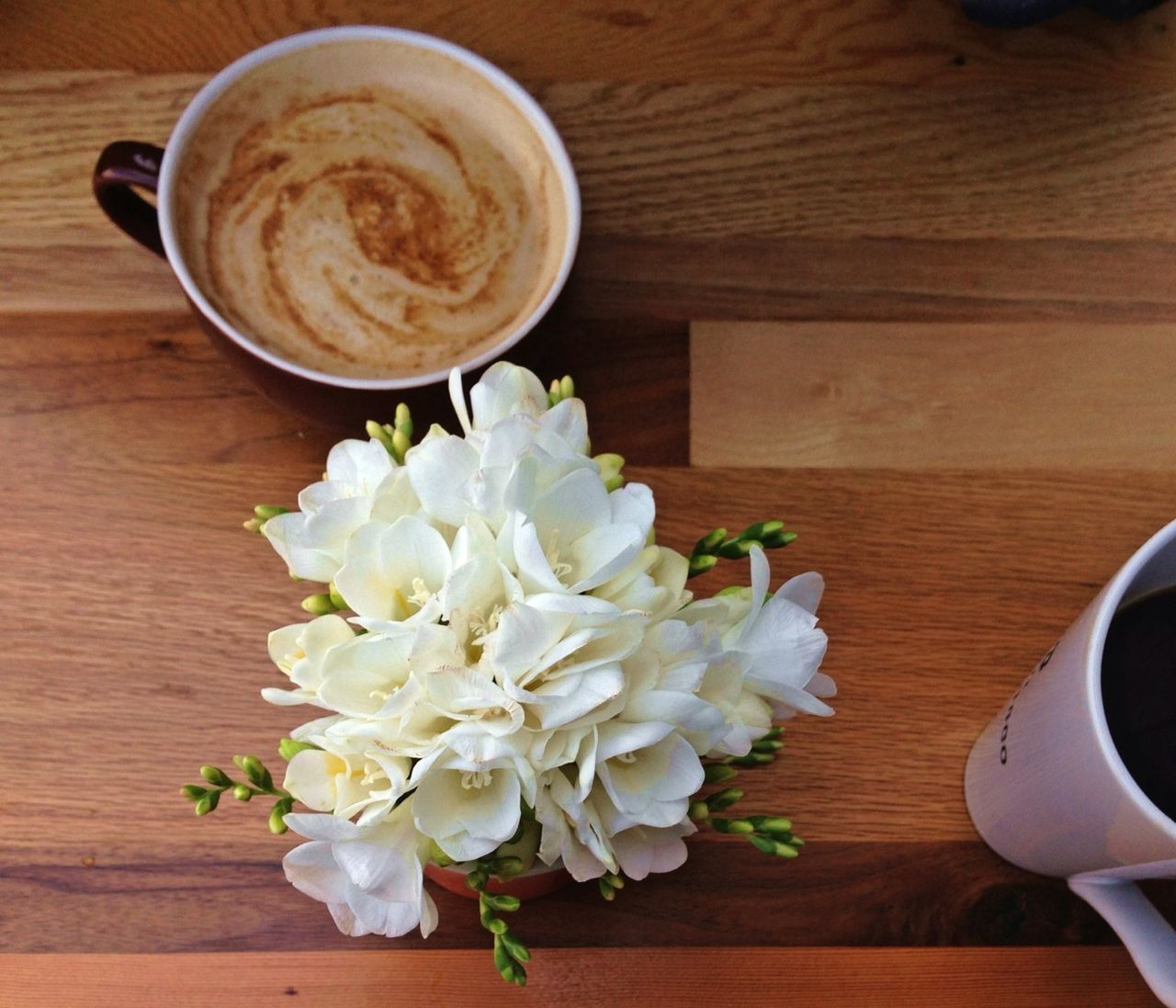 High angle view of coffee cups and flower pot on table