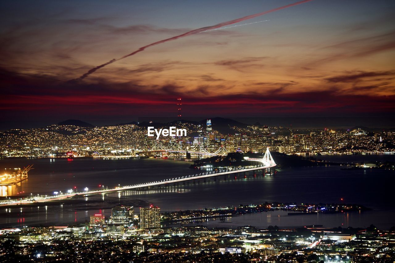 Illuminated cityscape against sky at night