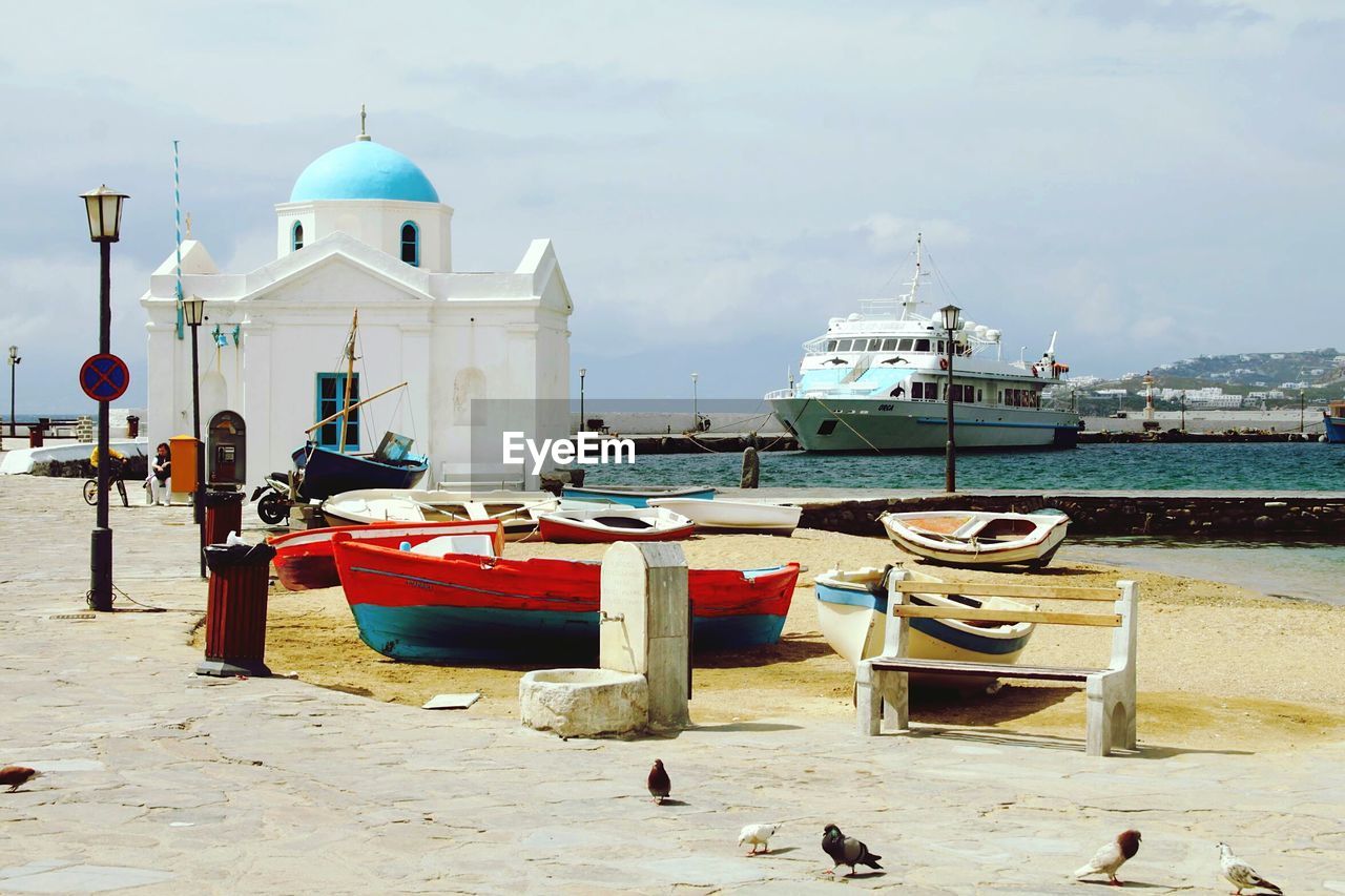 BOATS IN SEA WITH BUILDINGS IN BACKGROUND