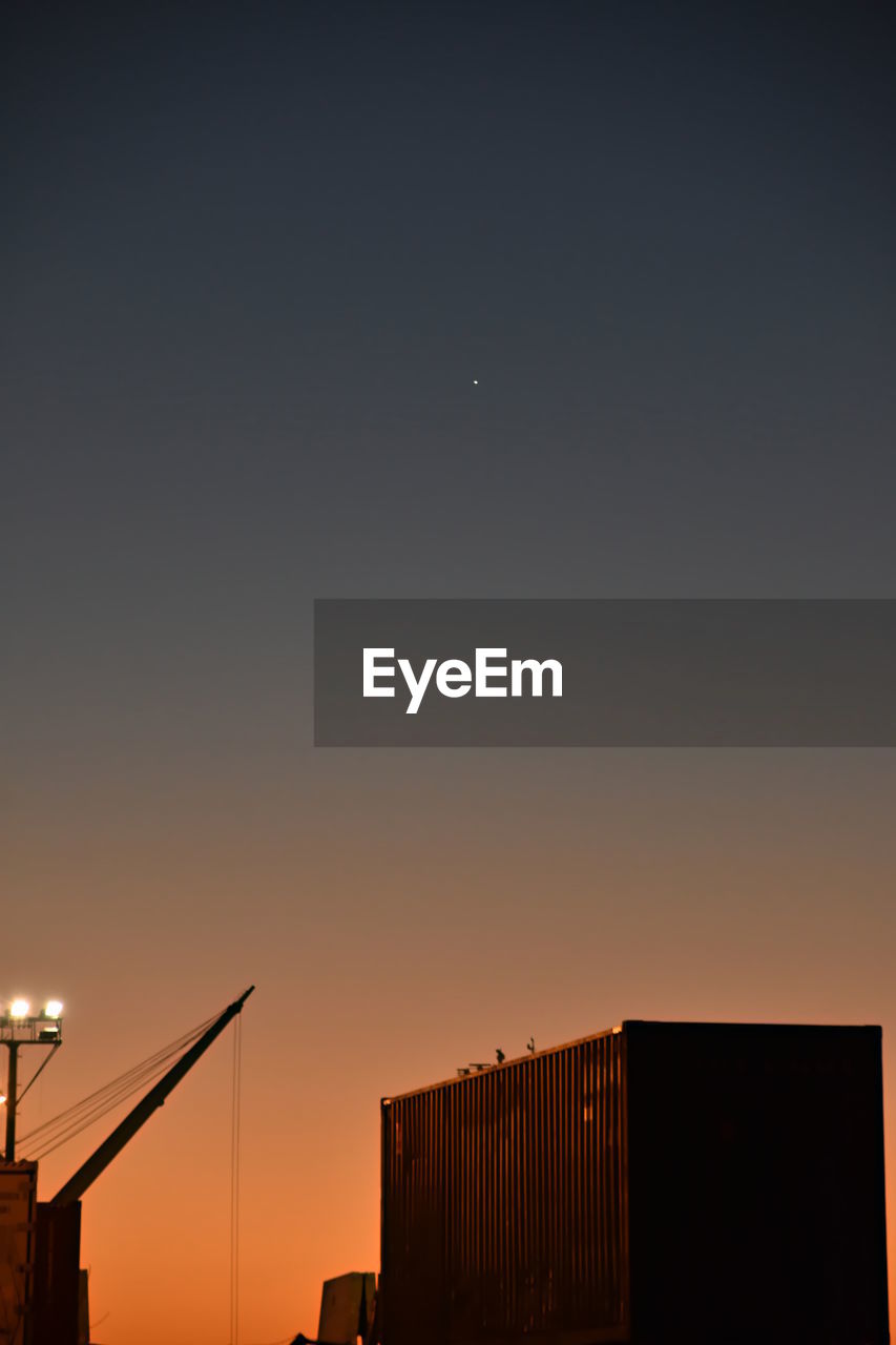 LOW ANGLE VIEW OF SILHOUETTE BUILDINGS AGAINST CLEAR SKY AT SUNSET