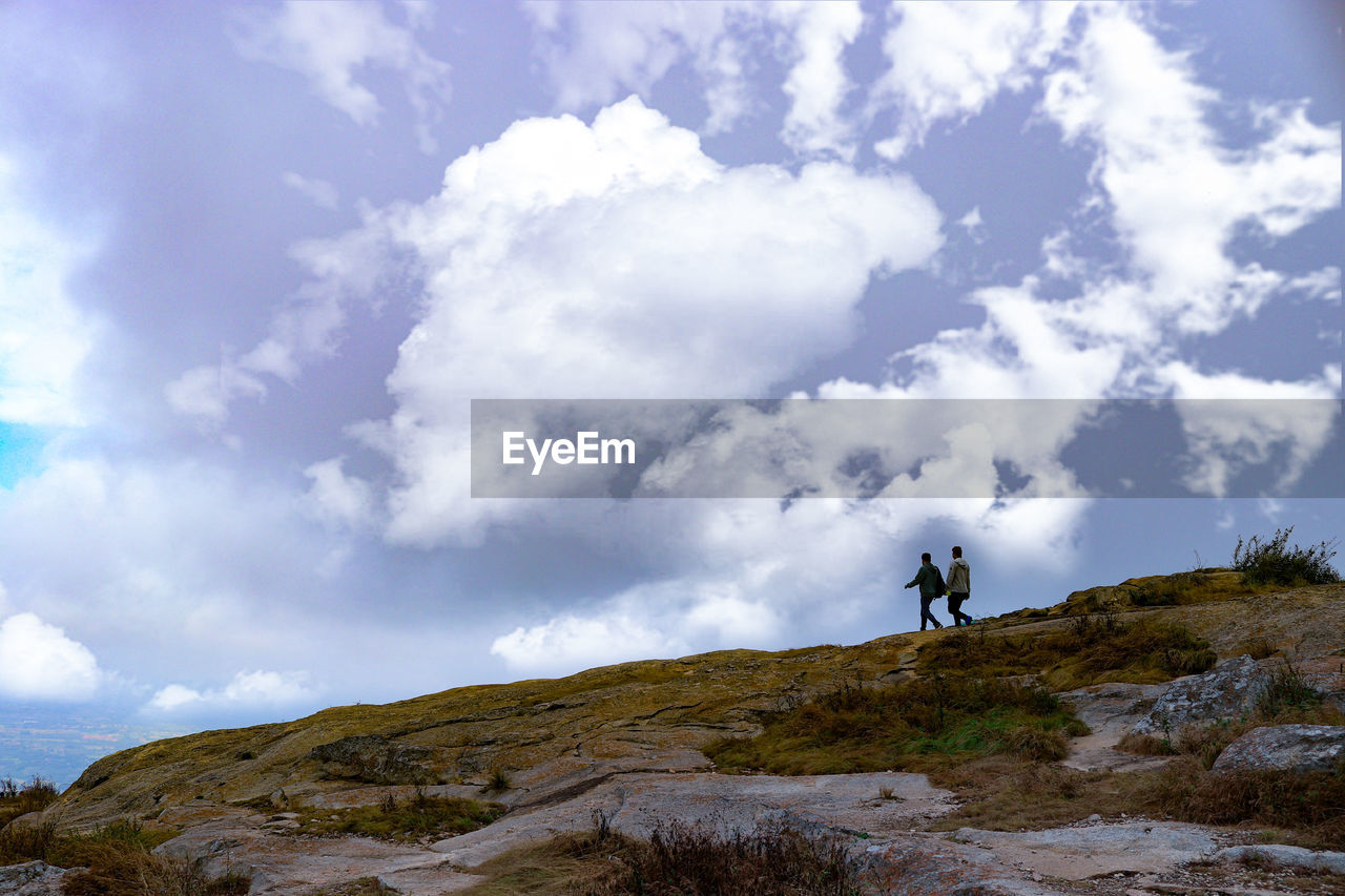 People on mountain against sky