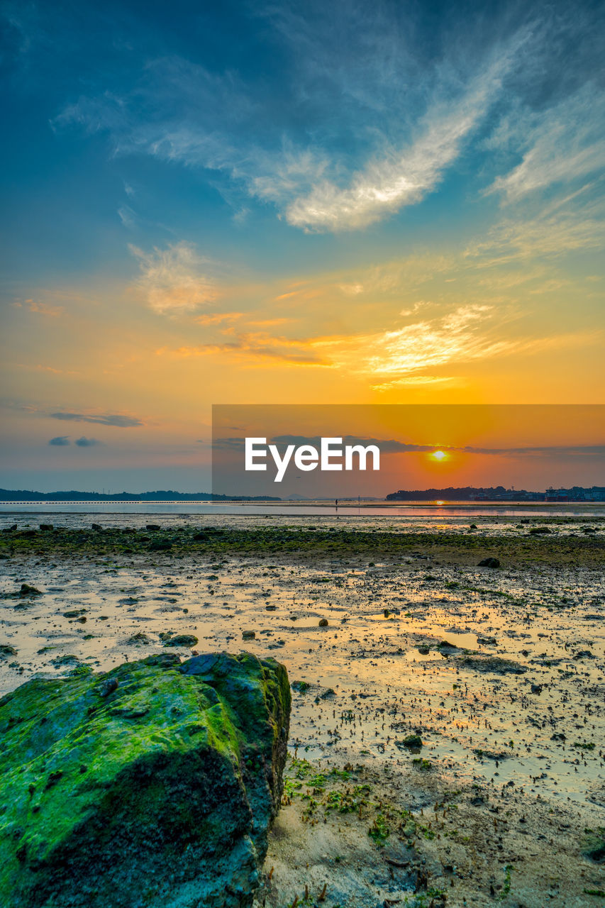 SCENIC VIEW OF BEACH DURING SUNSET