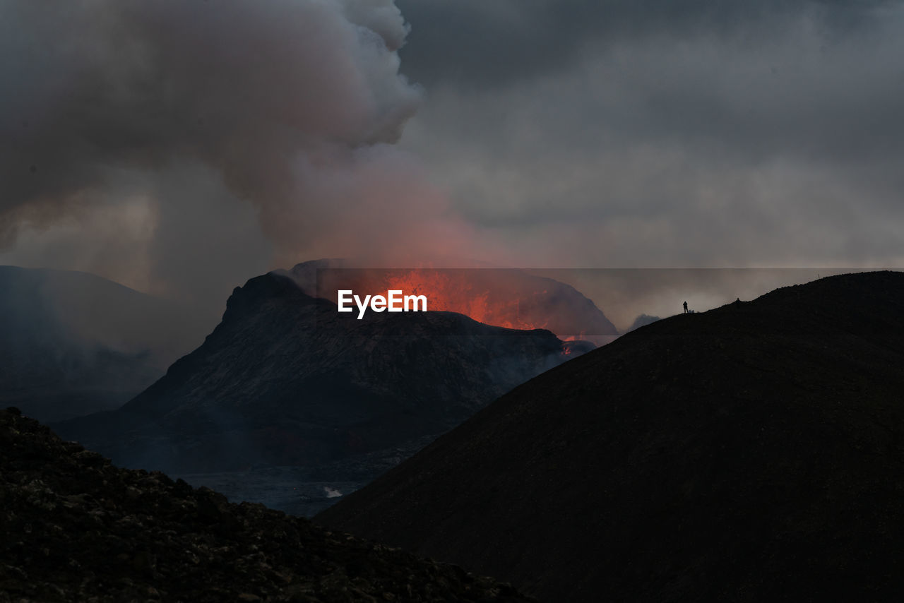 SMOKE EMITTING FROM VOLCANIC MOUNTAINS AGAINST SKY