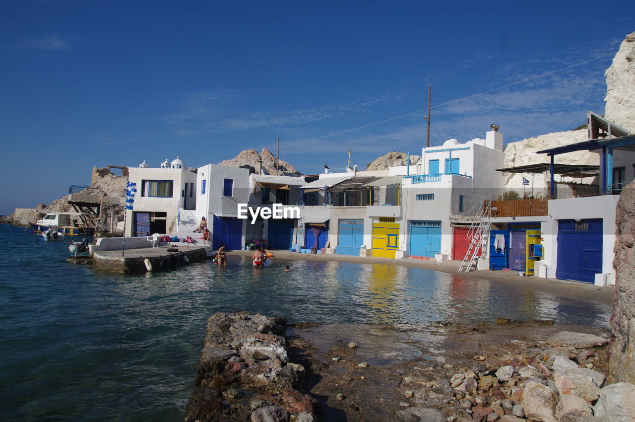 HOUSES ON SEA AGAINST SKY