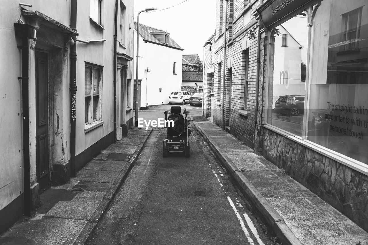 Motorised wheelchair navigating a narrow lane