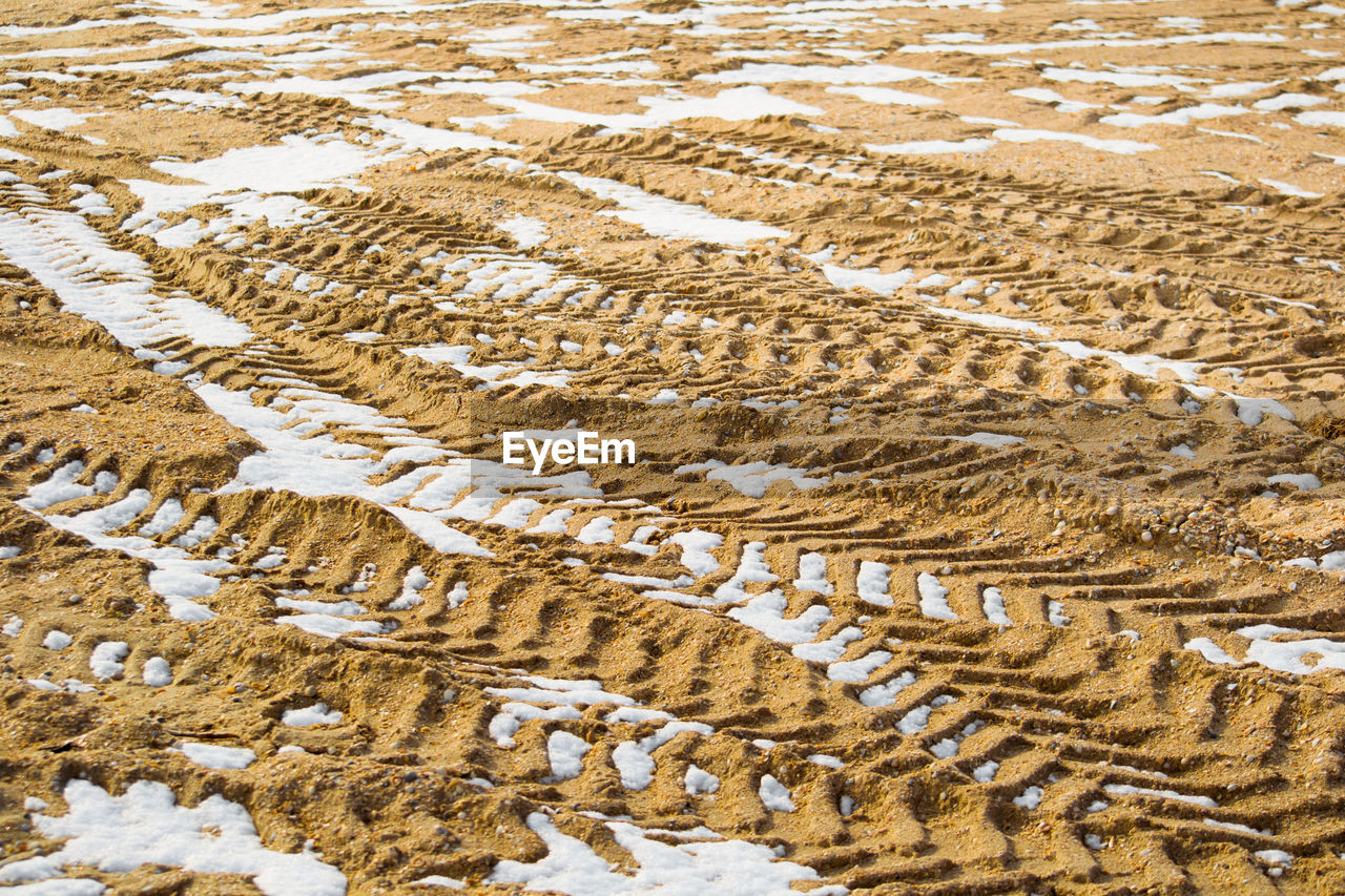 High angle view of tire tracks on field during winter