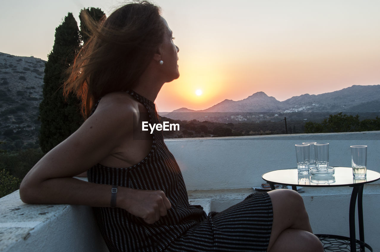 Woman relaxing on balcony at sunset