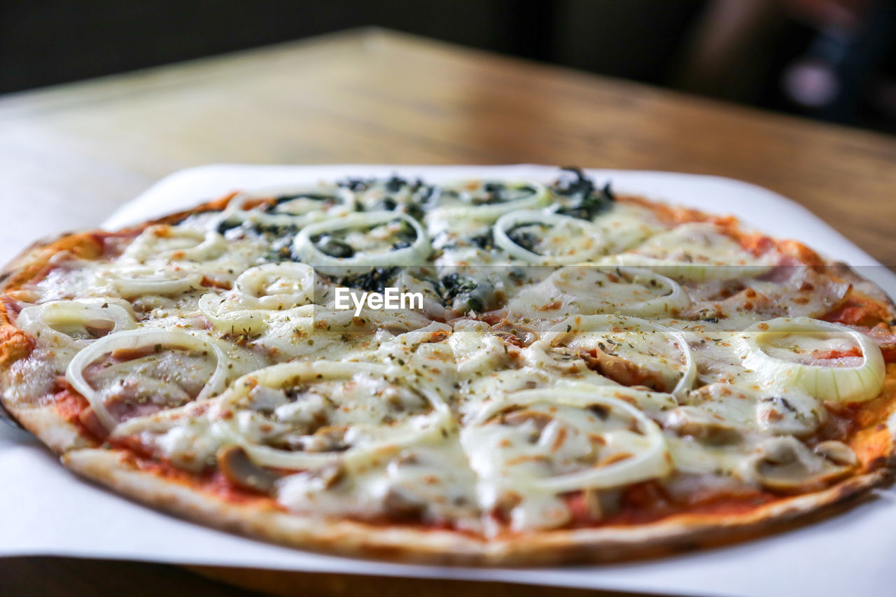 food, food and drink, pizza, fast food, italian food, dish, cuisine, cheese, freshness, dairy, vegetable, no people, healthy eating, fruit, restaurant, close-up, table, meal, baked, indoors, savory food, olive, mozzarella, plate, selective focus, tomato, fast food restaurant, wellbeing