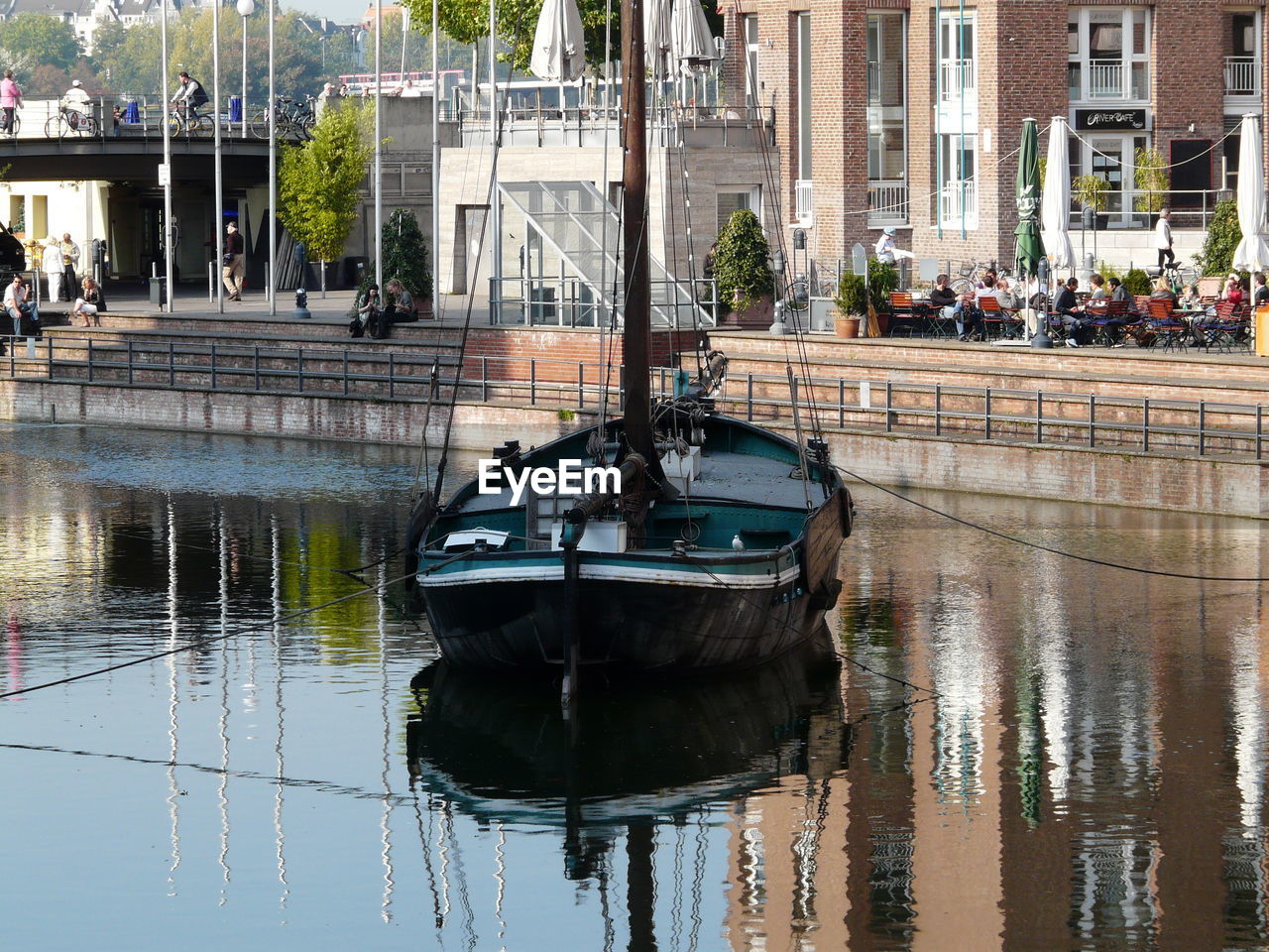 Boat moored in canal against building
