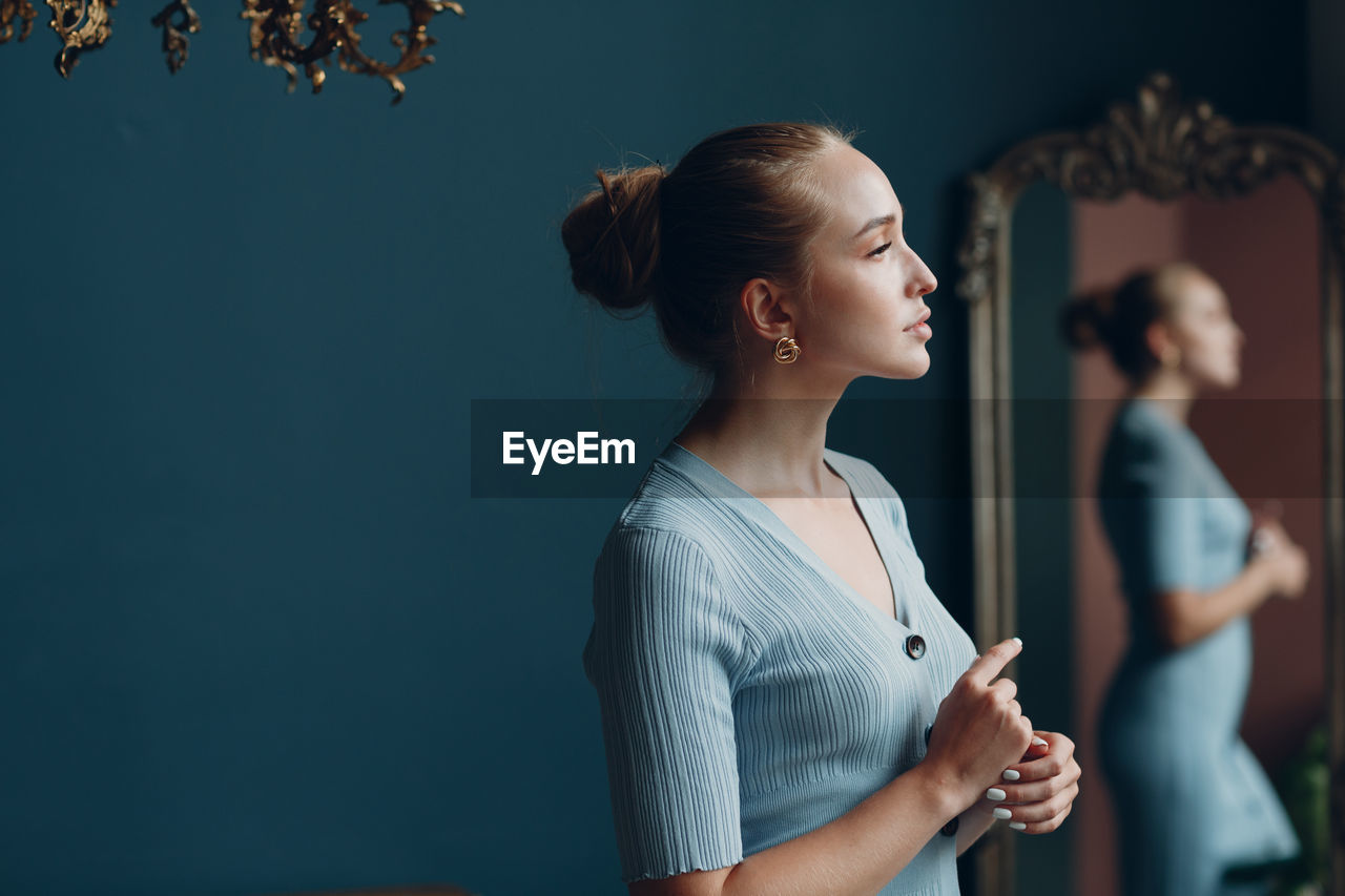 Side view of young woman looking at camera