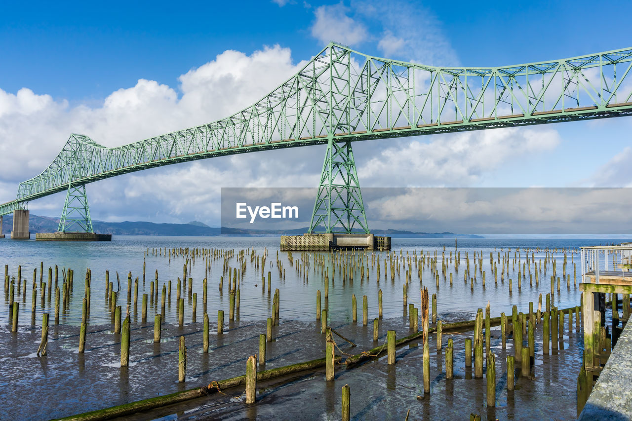 A view of the astoria-megler bridge that spans the columbia river. old pilings in the forground.
