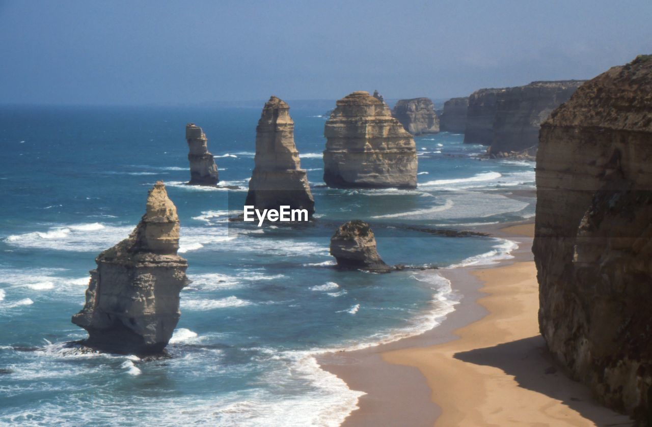 Rock formations in sea against clear sky