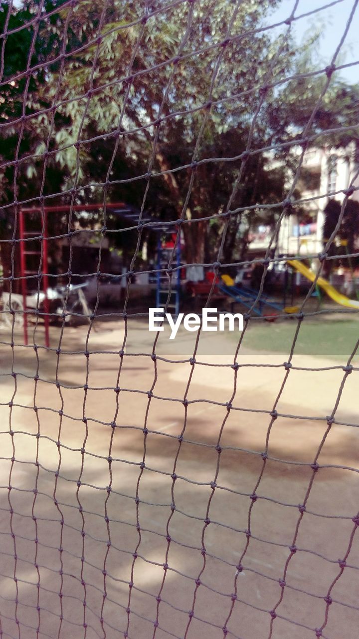 FULL FRAME SHOT OF CHAINLINK FENCE AGAINST TREE