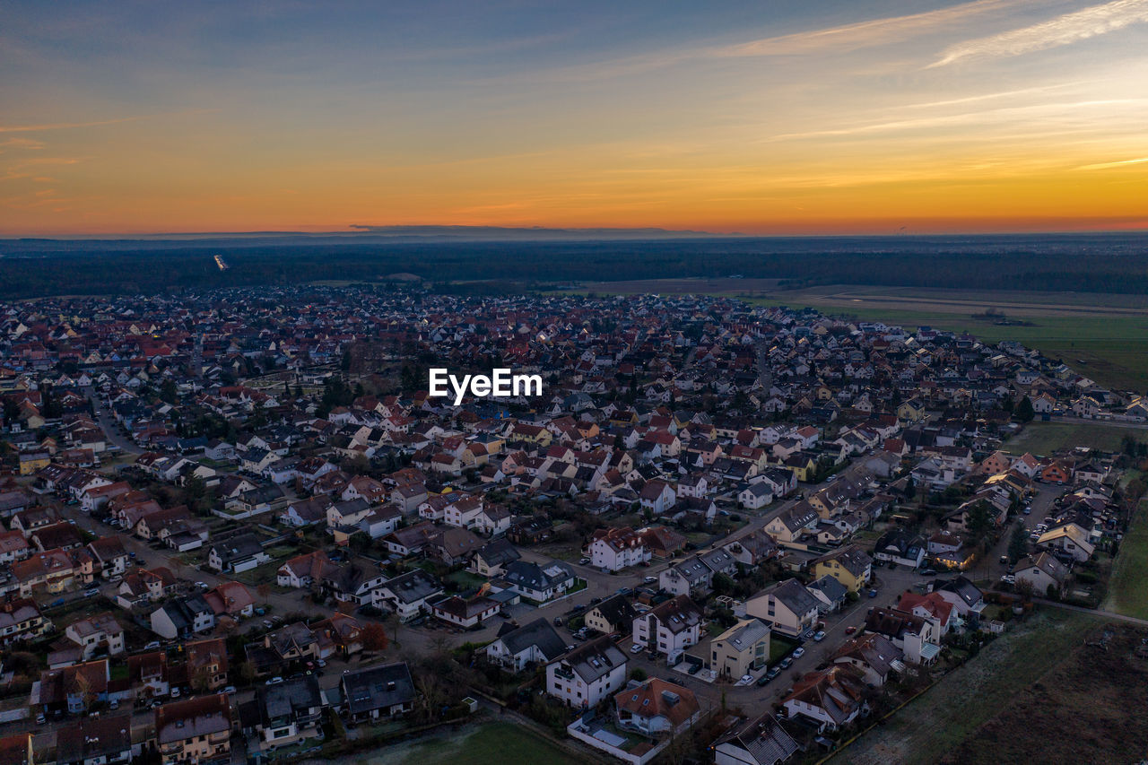 High angle shot of townscape against sky at sunset