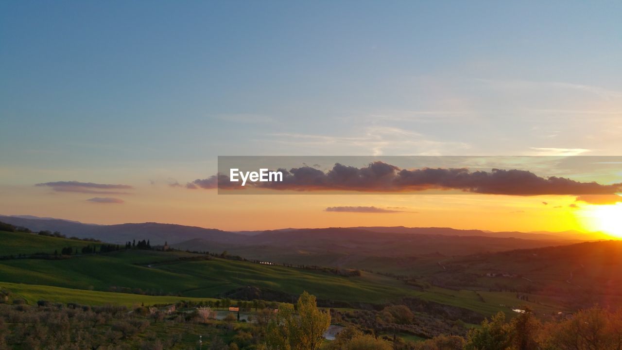 Scenic view of field against sky during sunset