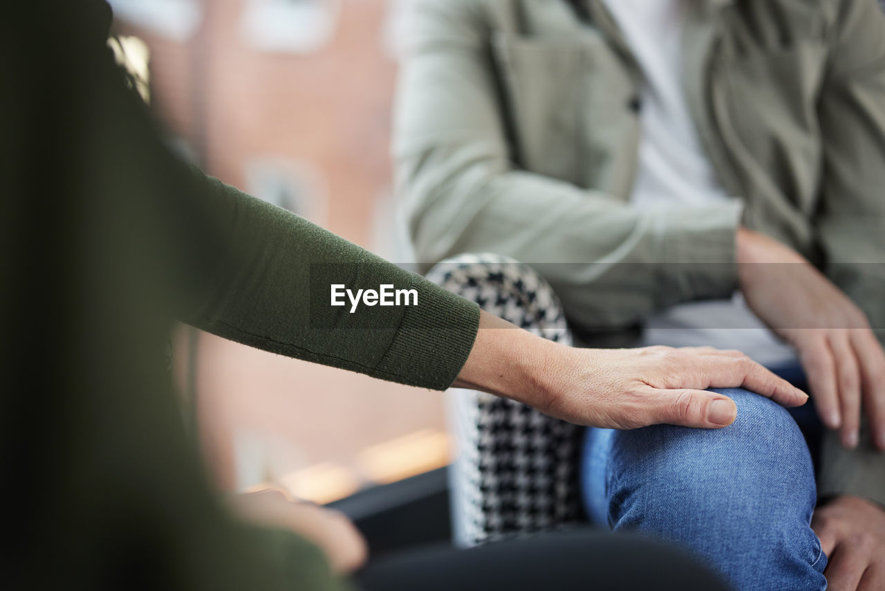 Female hand touching man's knee