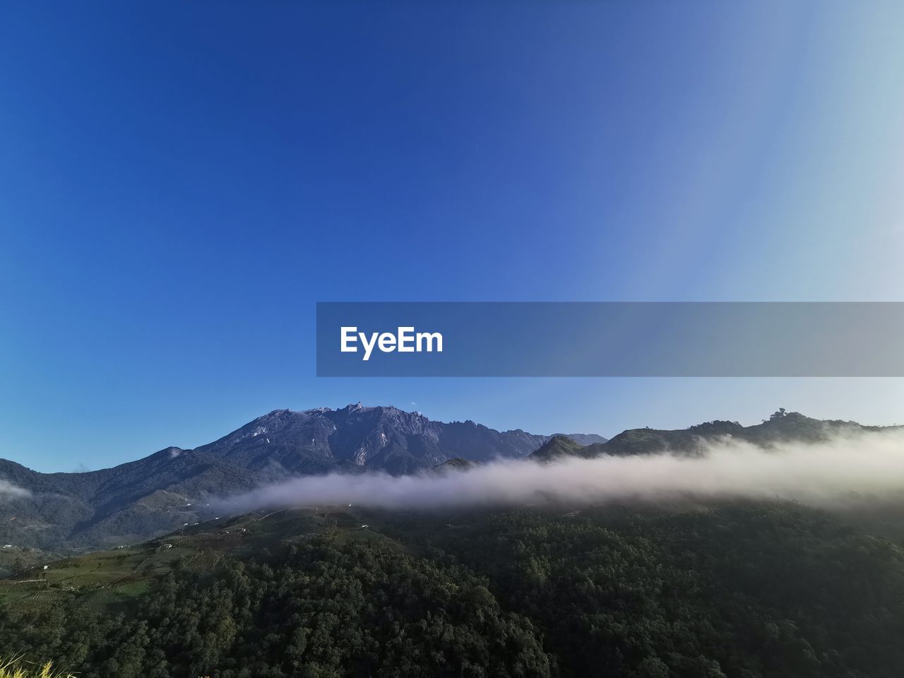 Scenic view of mountains against clear blue sky