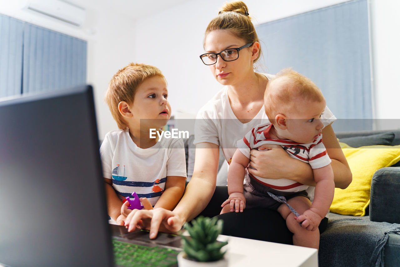 MOTHER AND DAUGHTER WHILE SITTING IN LAPTOP