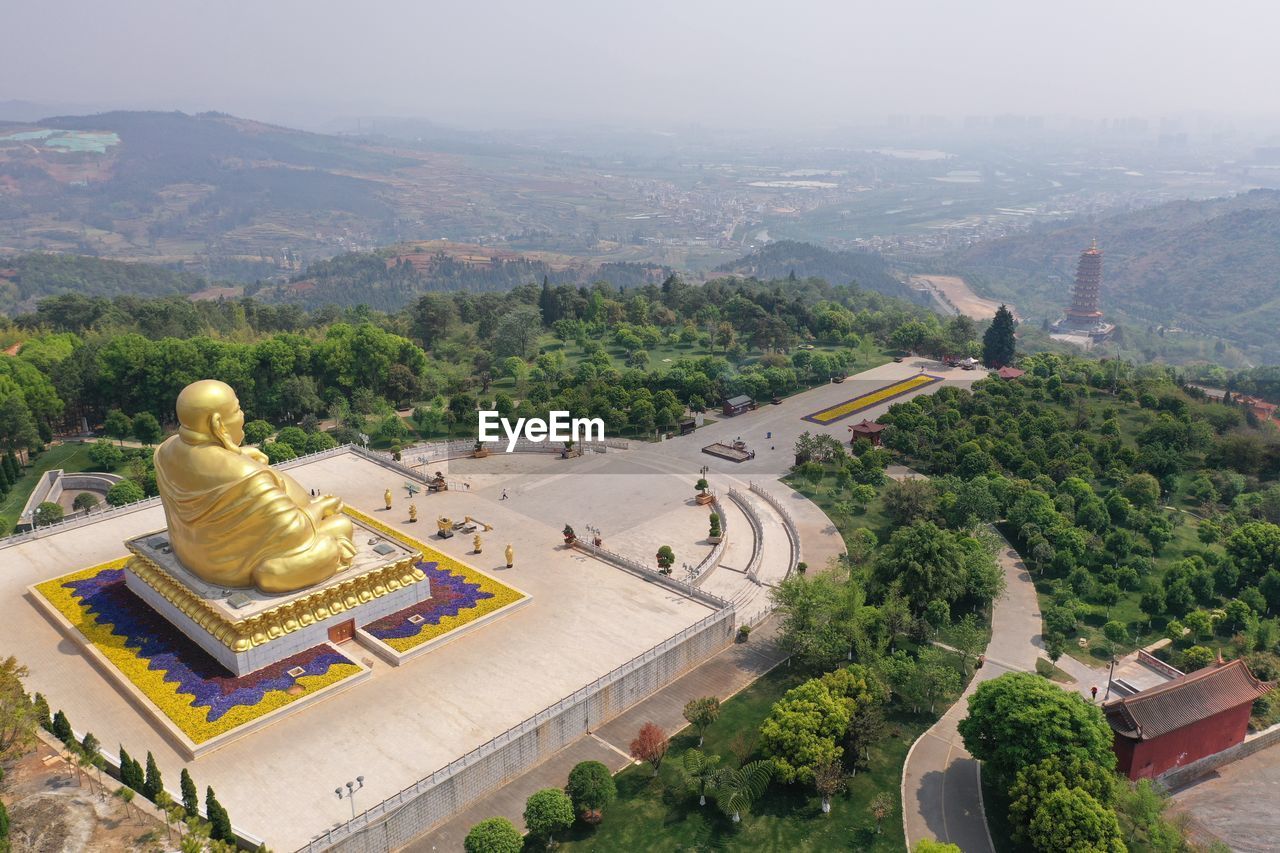 HIGH ANGLE VIEW OF STATUE BY TEMPLE AGAINST MOUNTAIN