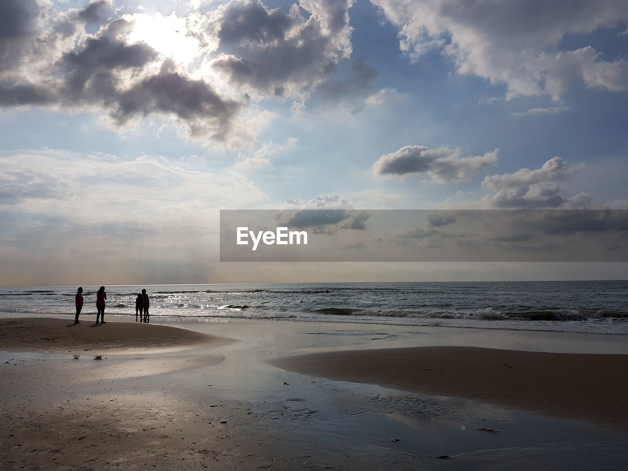 People at beach against sky