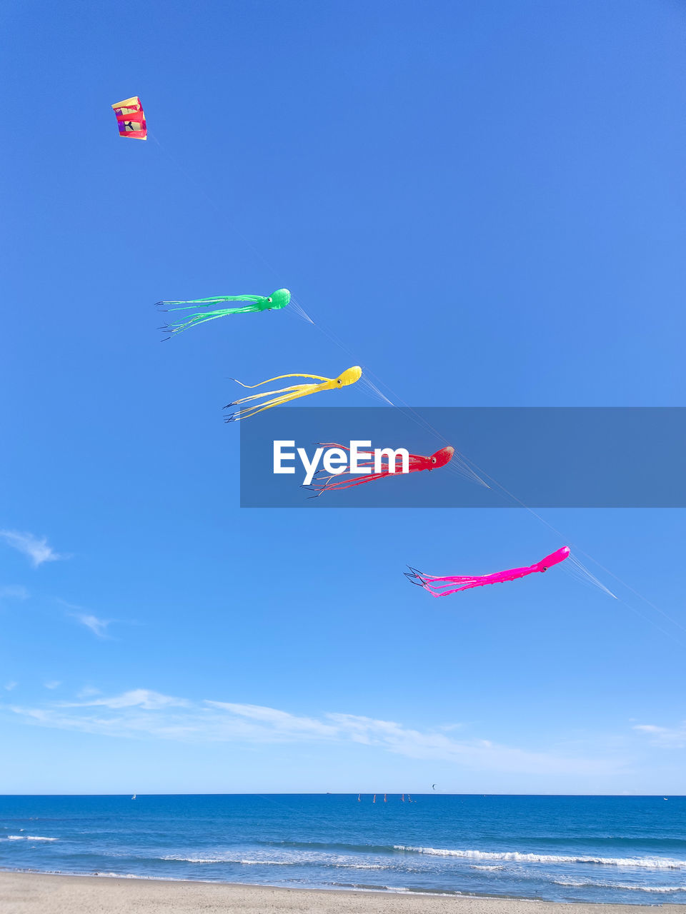 sky, kite sports, sea, kite - toy, water, blue, kite, sports, nature, toy, land, windsports, flying, beach, individual sports, horizon over water, horizon, sport kite, day, holiday, multi colored, beauty in nature, wind, environment, motion, vacation, cloud, no people, clear sky, trip, outdoors, scenics - nature, sunny, tranquility, travel, tranquil scene, travel destinations, leisure activity, summer