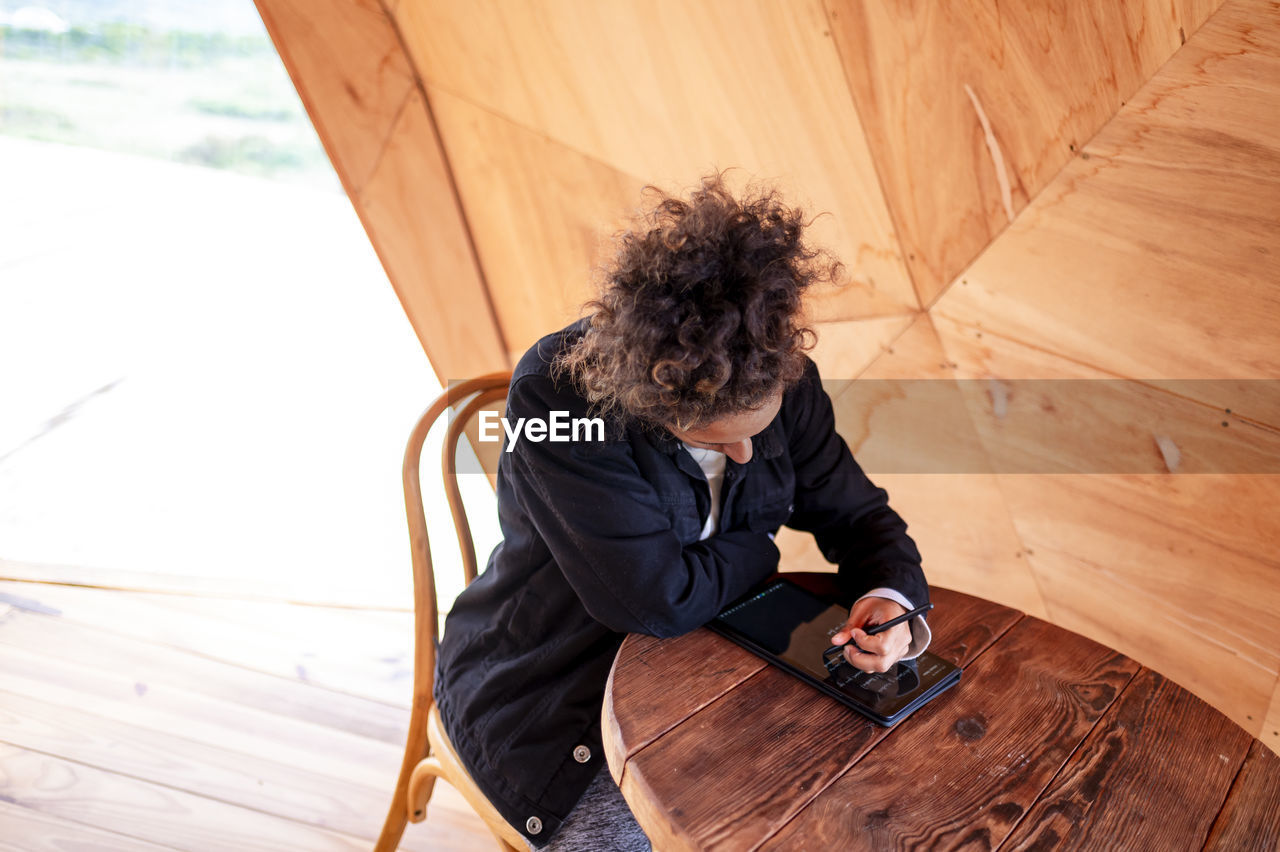 Woman using a digital tablet with pen in a dome tent.