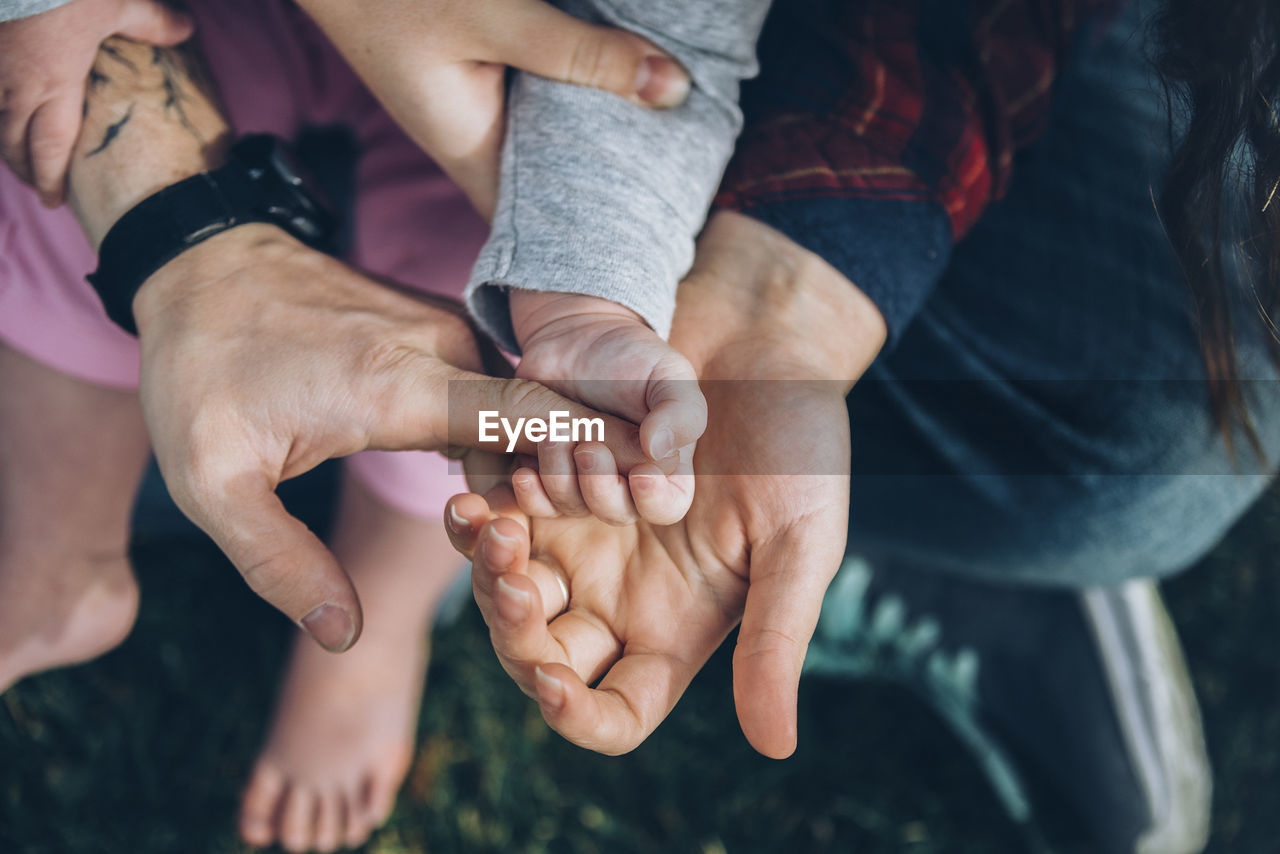 HIGH ANGLE VIEW OF MAN AND PEOPLE ON HANDS