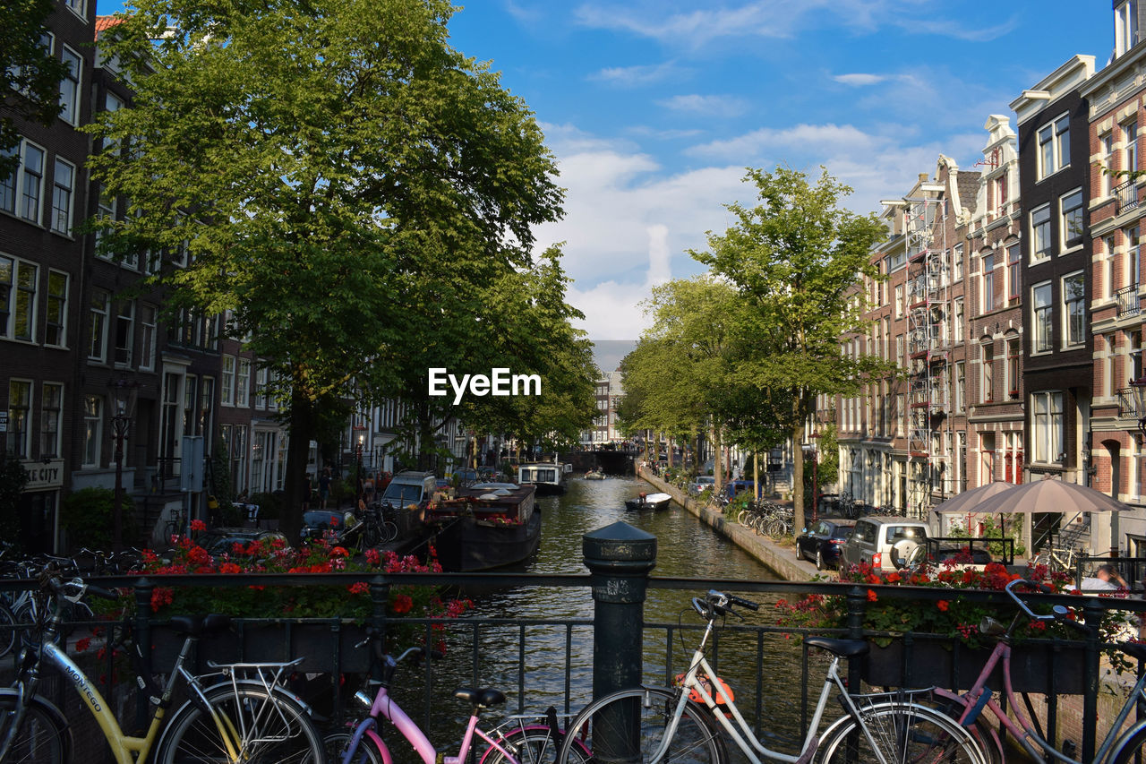 BICYCLE BY CANAL AMIDST BUILDINGS IN CITY