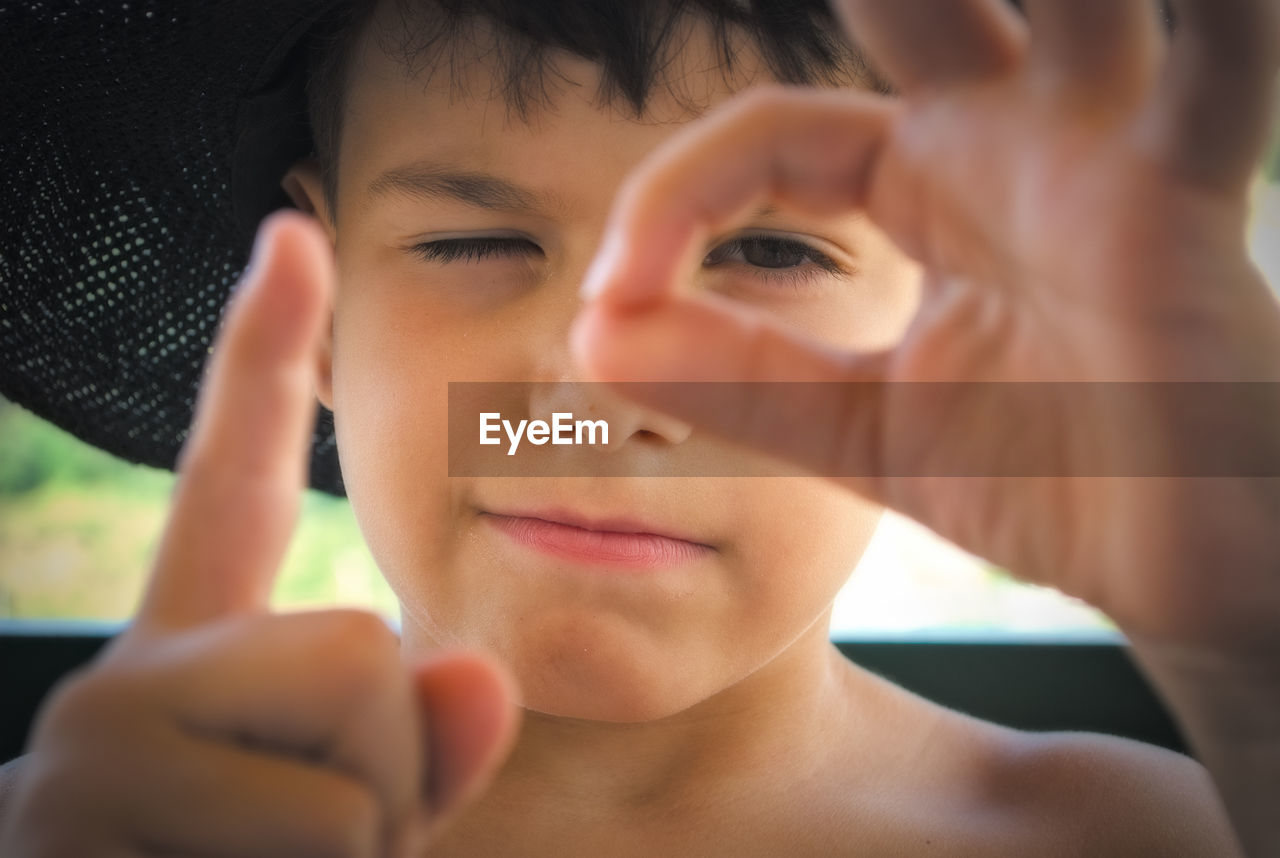 Close-up portrait of boy gesturing outdoors
