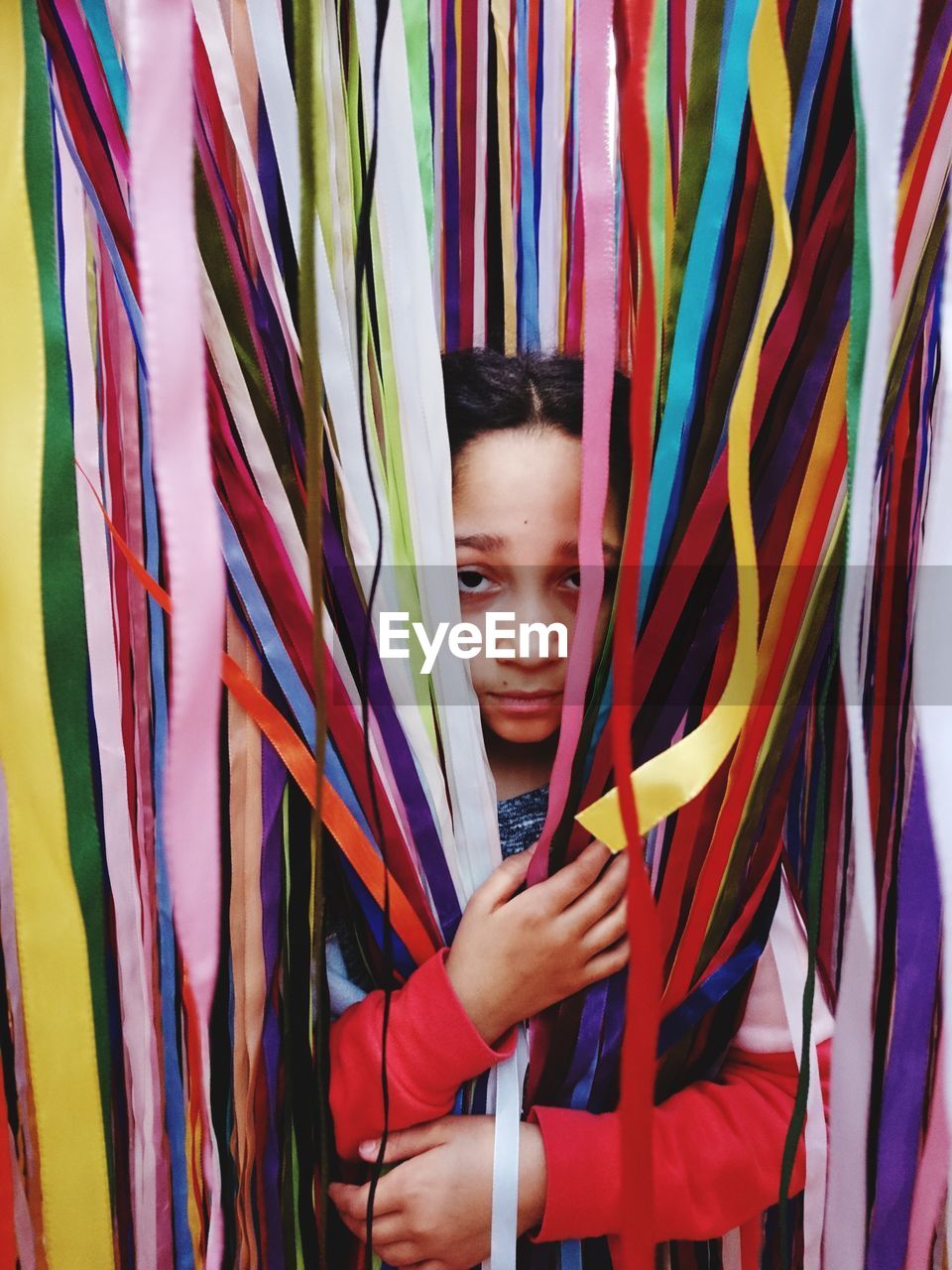 Portrait of girl holding multi colored ribbons